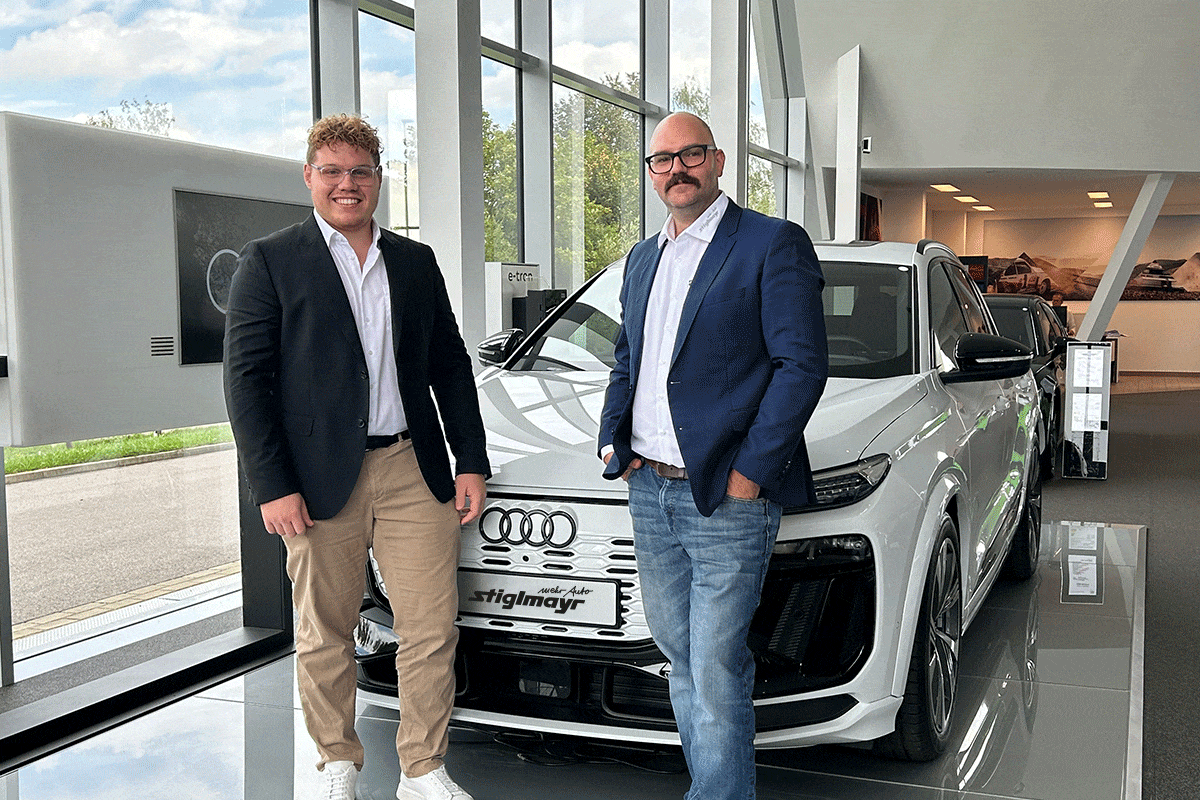 Zwei Großkundenverkäufer stehen vor einem weißem Audi.
