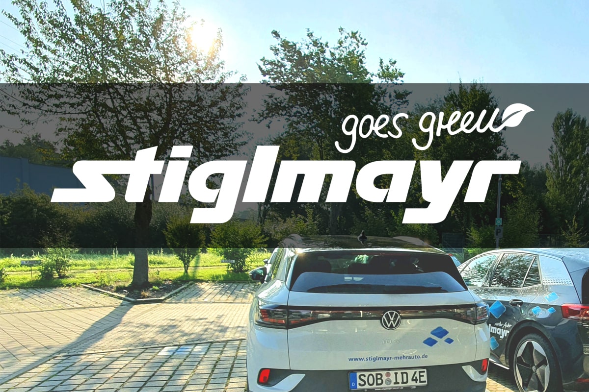 Bild zeigt das Logo Stiglmayr goes green.Im Hintergrund zu sehen ist ein Volkswagen, der in der Natur steht.