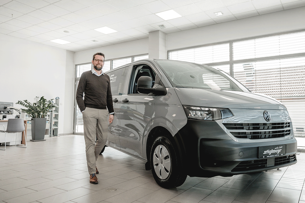 Nutzfahrzeug Verkäufer Oliver Schroeder vor einem VW Transporter